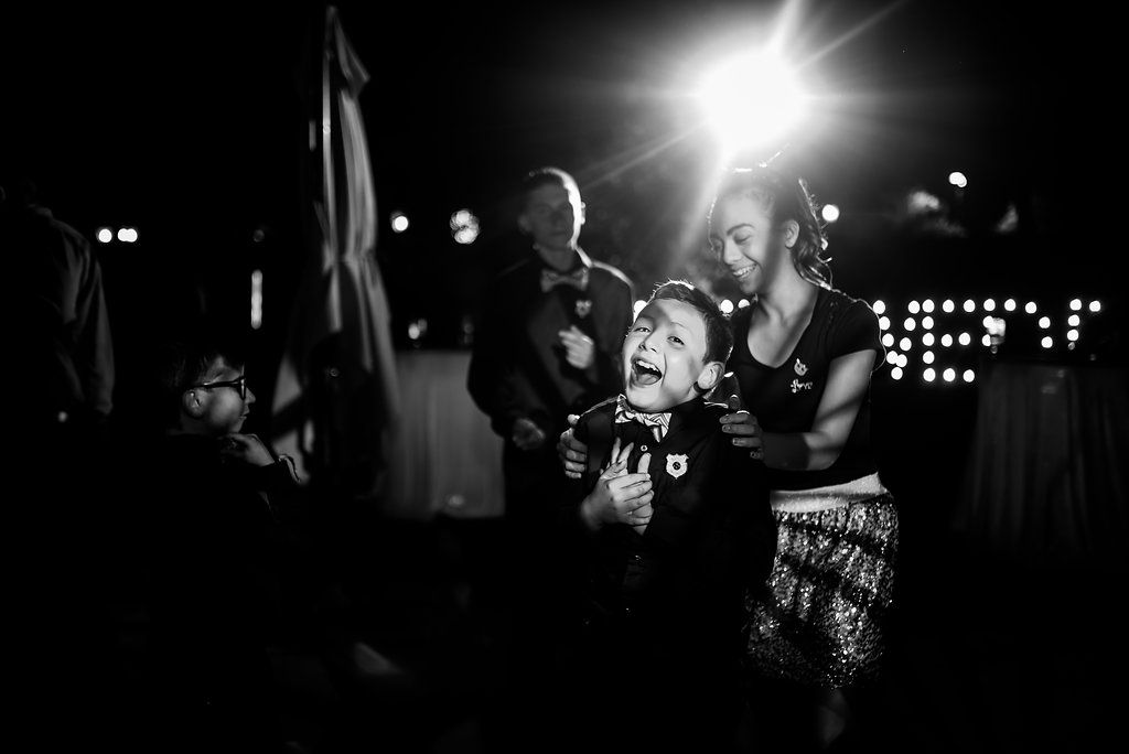 Black and white photo of energetic wedding reception celebration with bright highlights.
