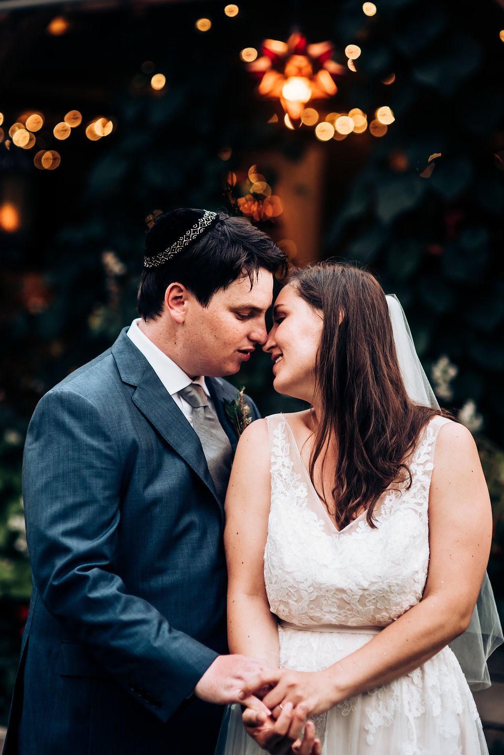 Intimate wedding portrait with soft bokeh lights and warm evening atmosphere.