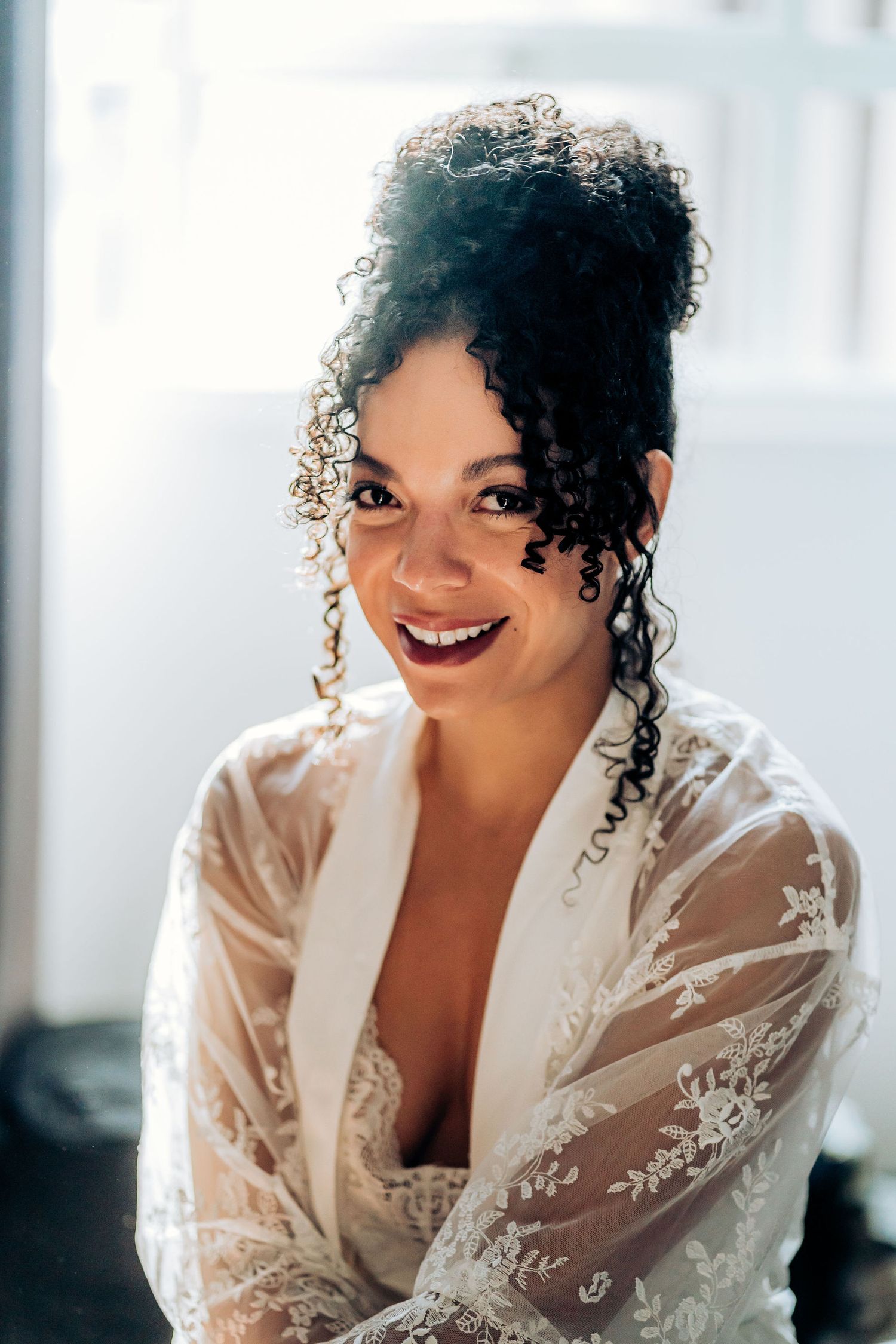 Joyful bridal portrait with natural window lighting.