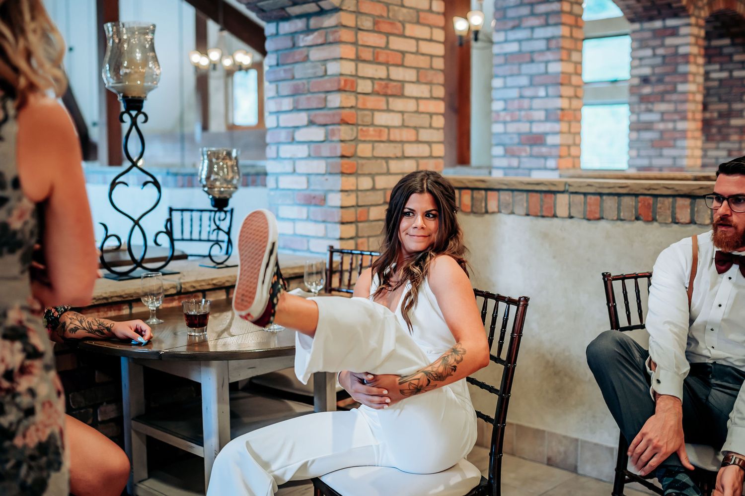 Wedding celebration in a rustic brick venue with elegant table settings.