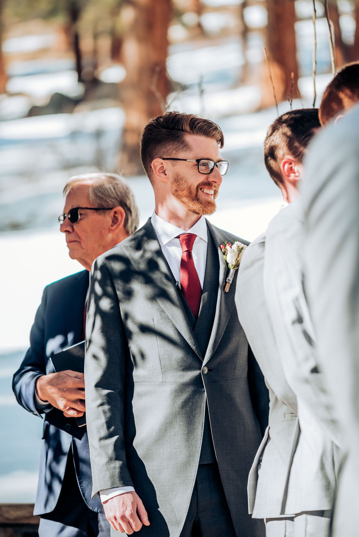 Wedding party members in formal attire gathered at outdoor winter ceremony.