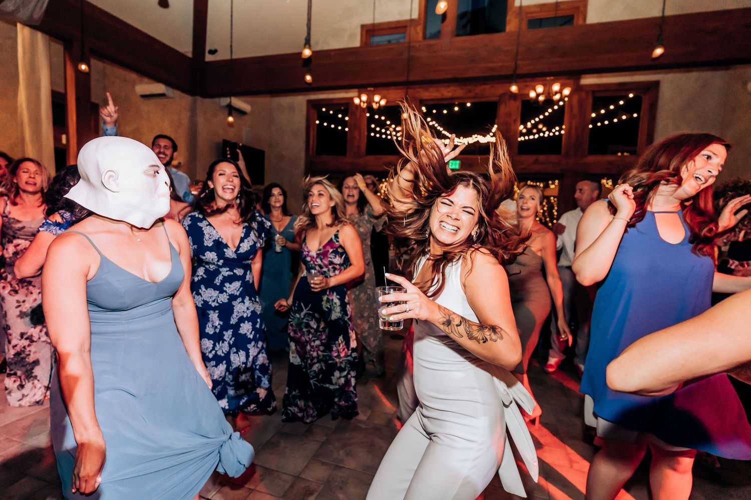Energetic wedding guests dancing and celebrating on a packed dance floor.