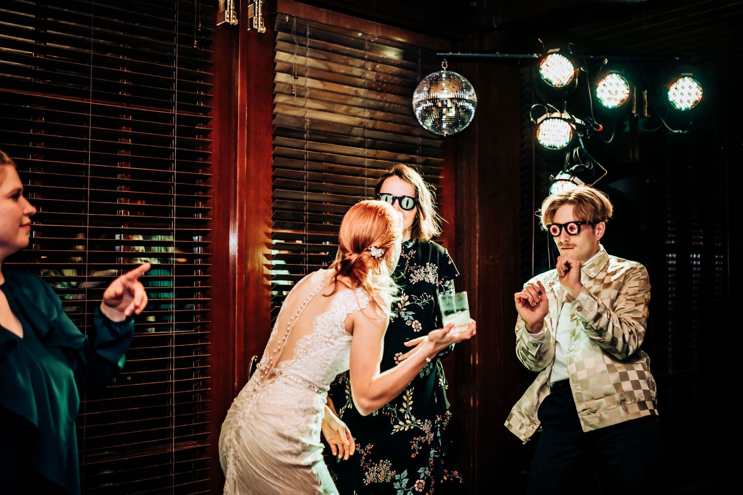 A group dancing and having fun at a nightclub under disco ball lighting.