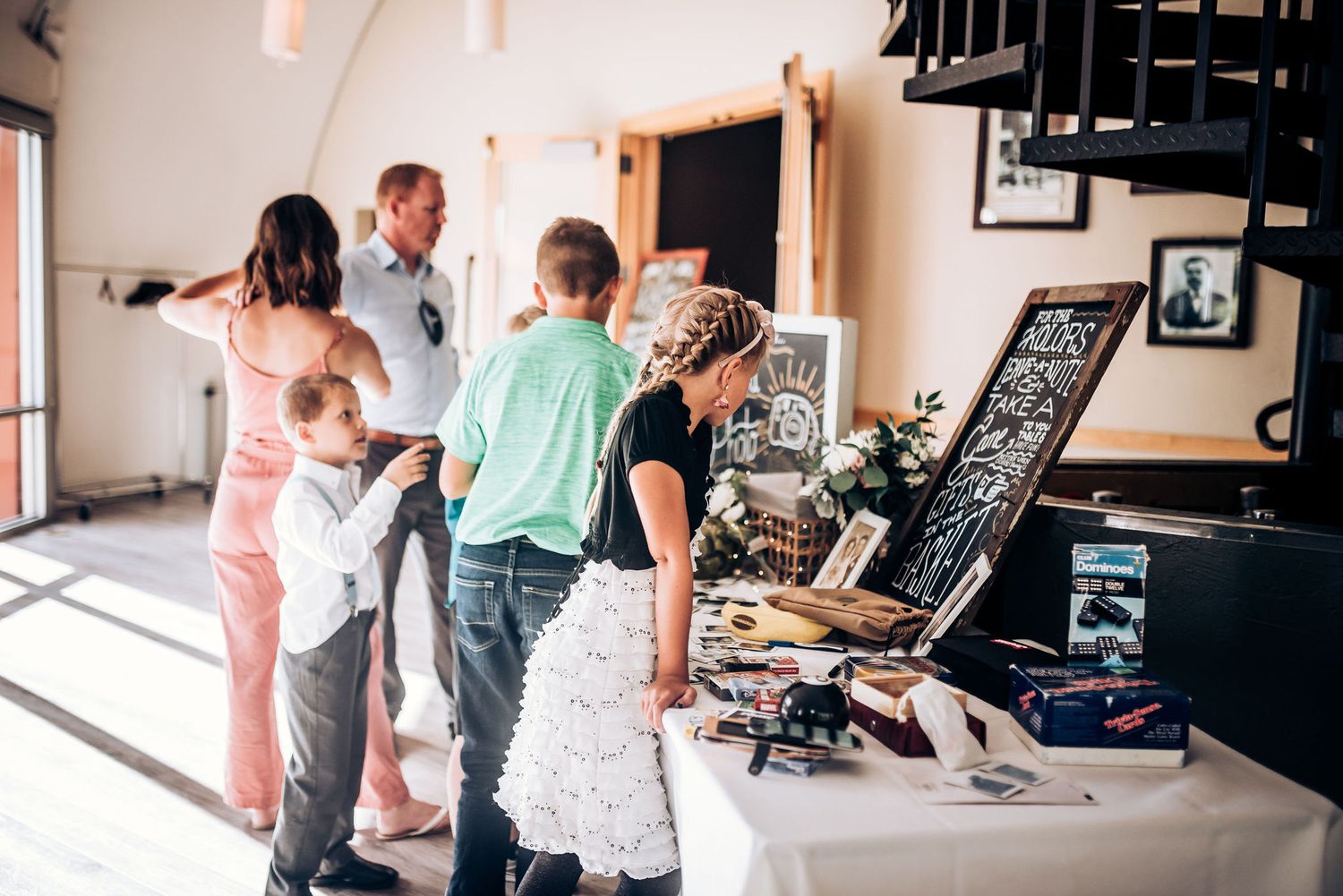 Guests viewing display table with decorative signs and mementos at daytime event.