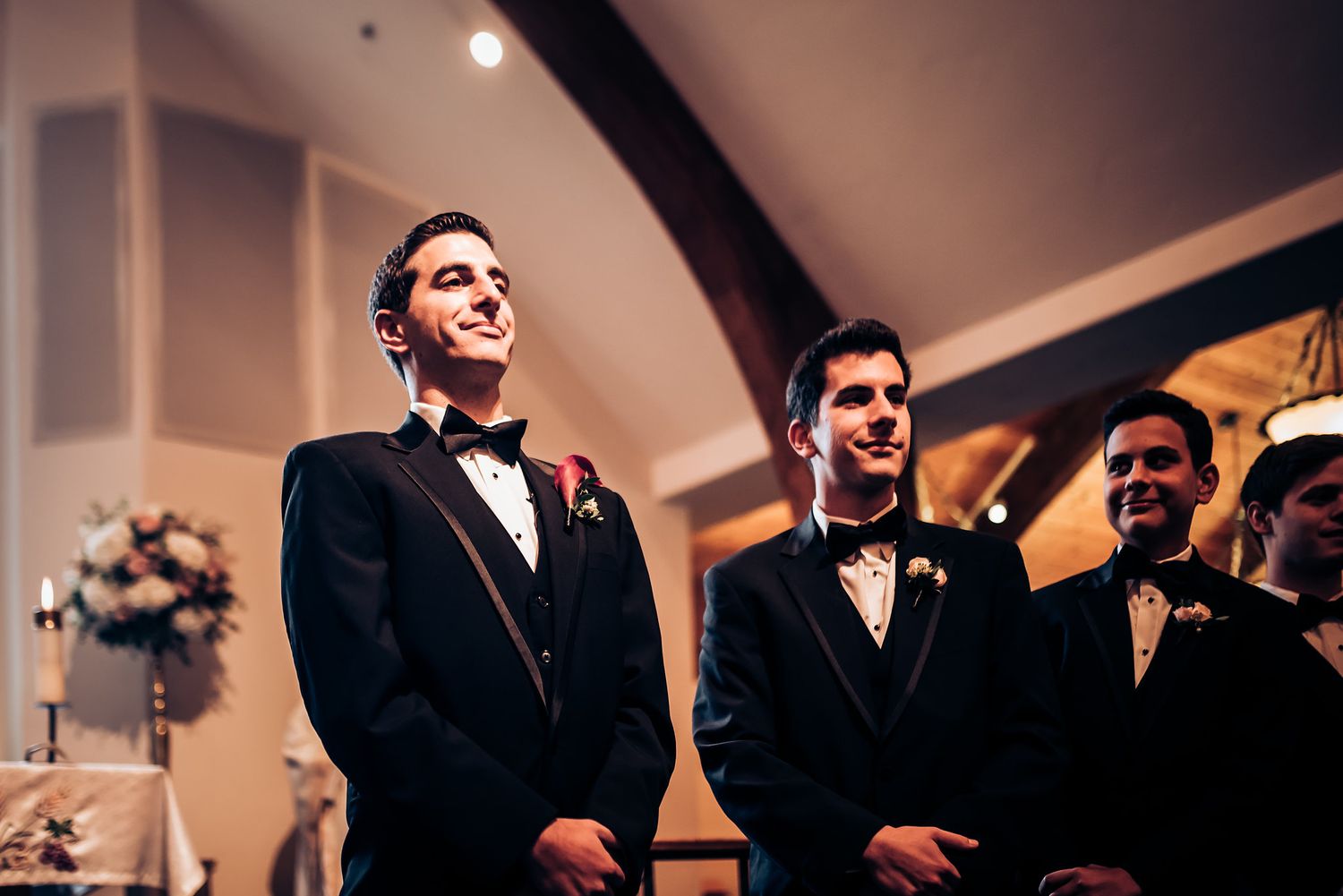 Wedding ceremony participants in formal attire gathered at the altar.