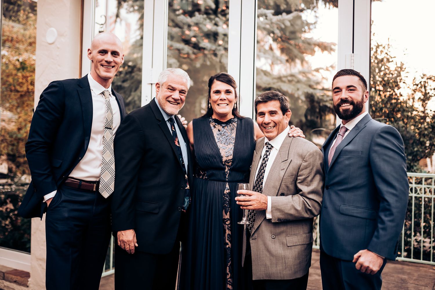 Group of formally dressed guests gathered outdoors at an elegant event.
