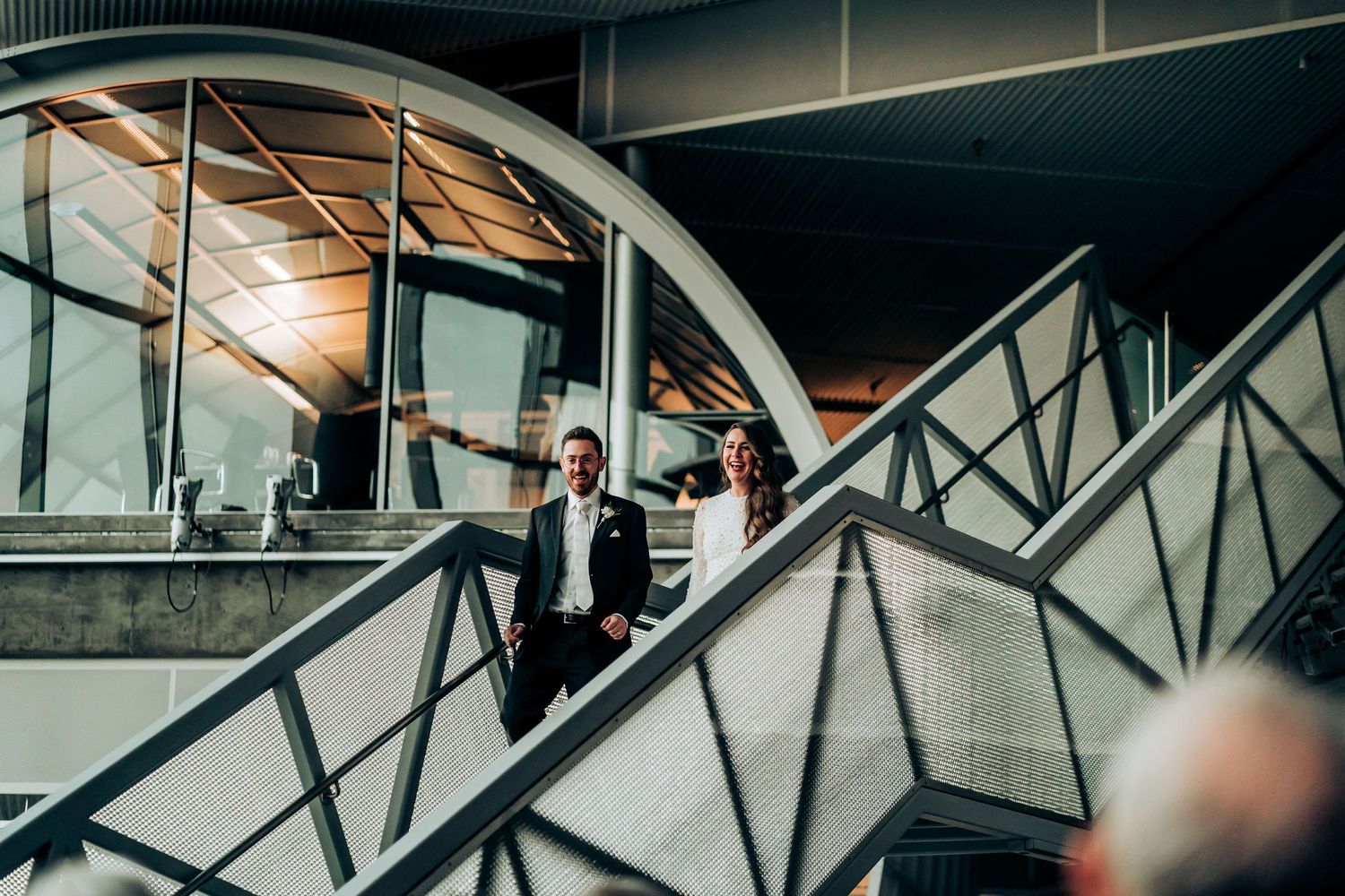 Artistic silhouette of couple on modern architectural staircase with dramatic lighting.