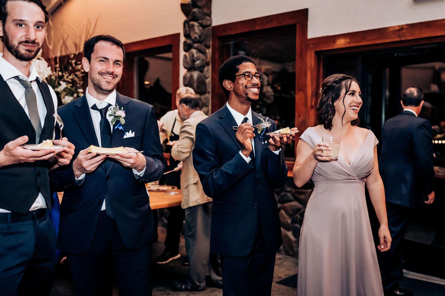 Wedding party members enjoying drinks and conversation during the reception celebration.