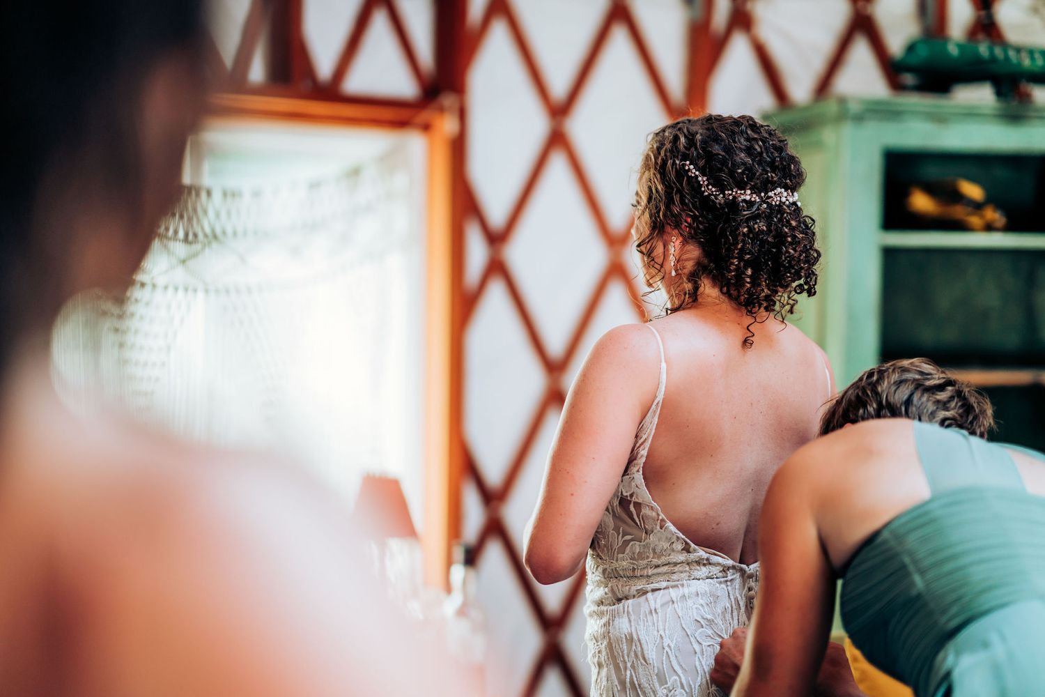 Candid moment captured inside a yurt during wedding preparations.