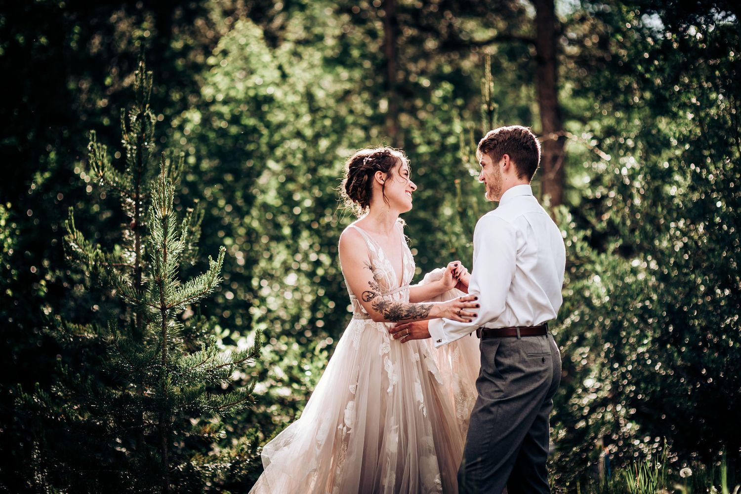 A tender moment between newlyweds surrounded by lush forest greenery.