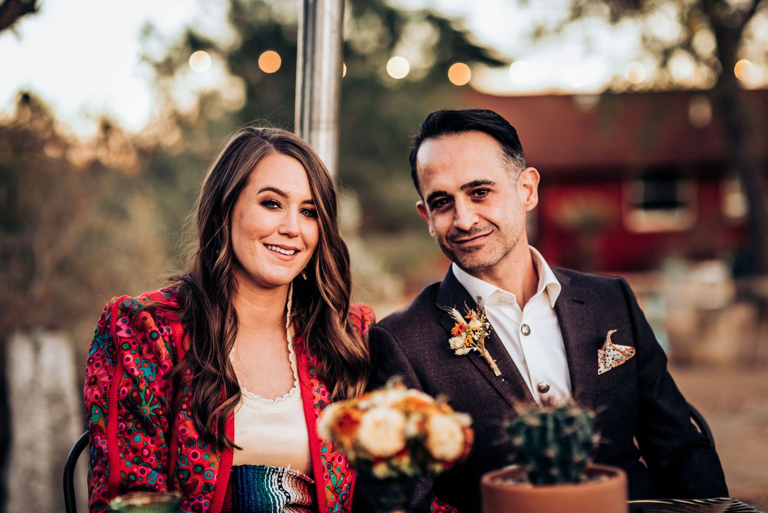 A couple dressed elegantly pose during a desert celebration.