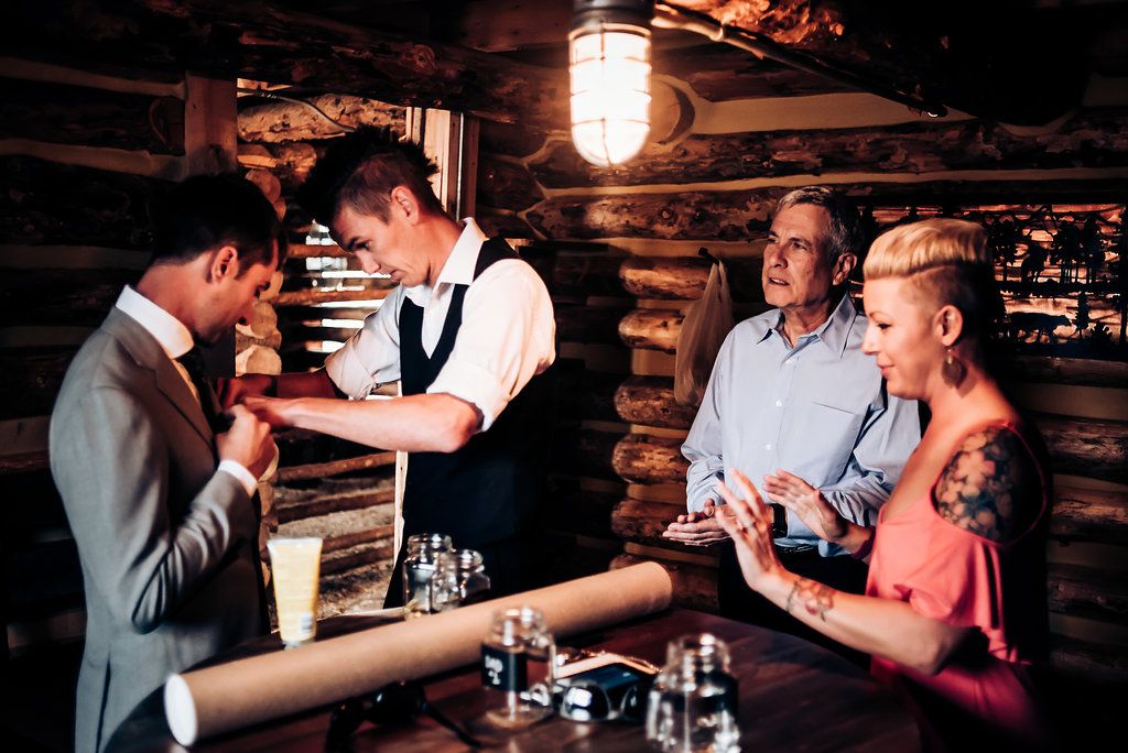 Group gathered at rustic wooden bar enjoying drinks and conversation.