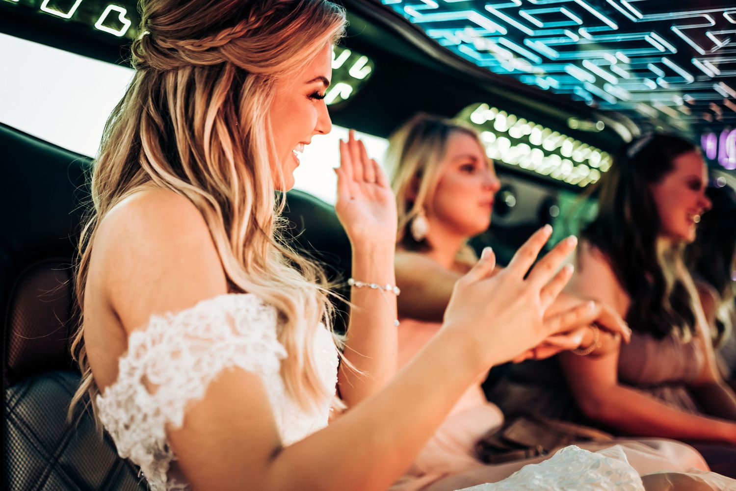 People clapping and celebrating inside a luxury vehicle with decorative blue lighting.