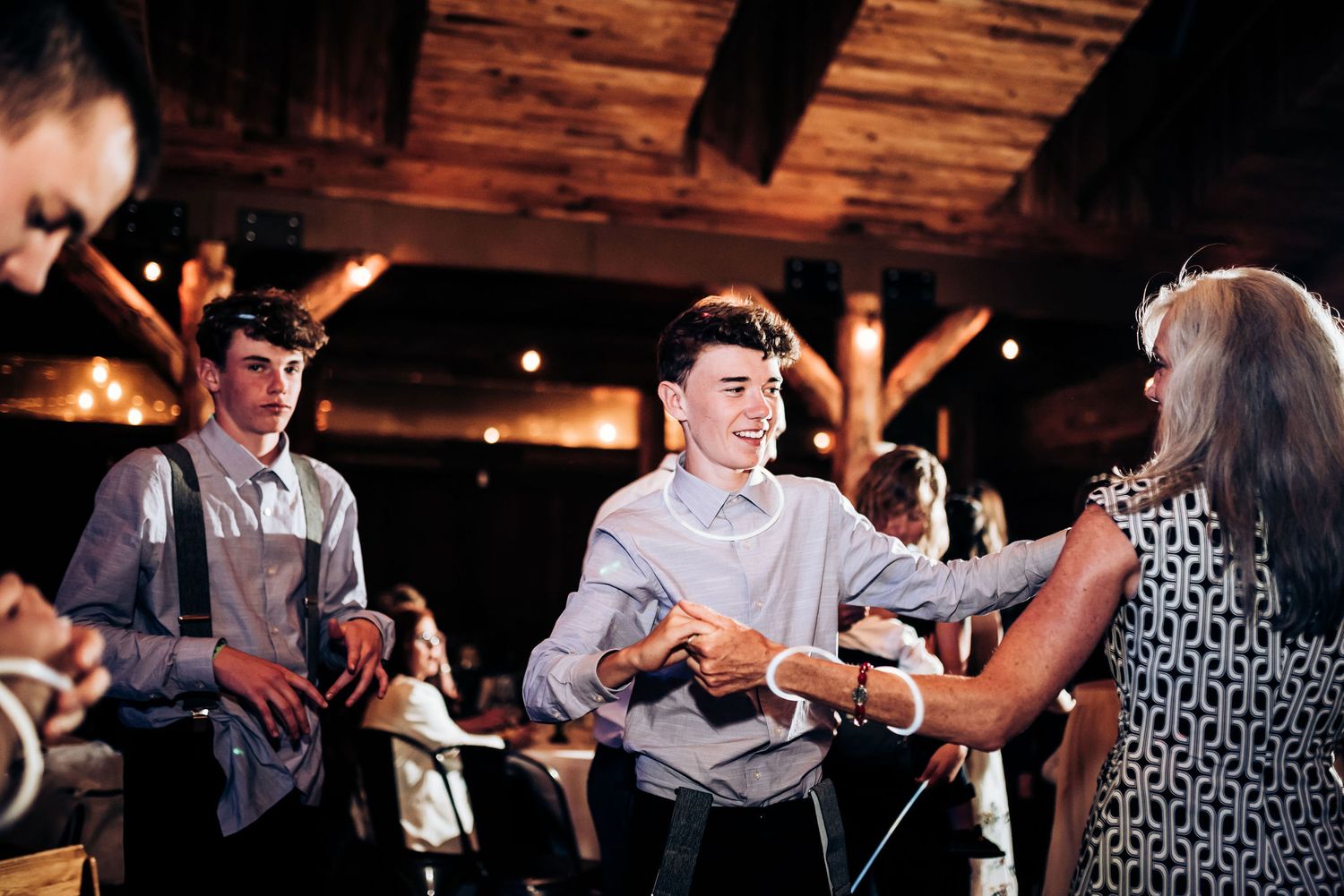 Wedding guests participating in a fun group activity at a rustic reception venue.