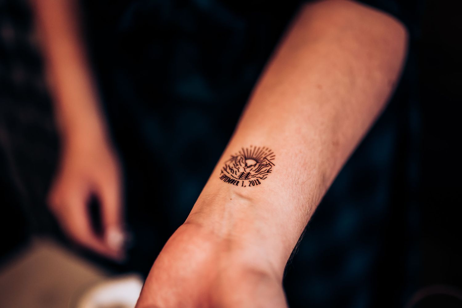 Close-up of floral temporary tattoo or henna design on person's forearm.