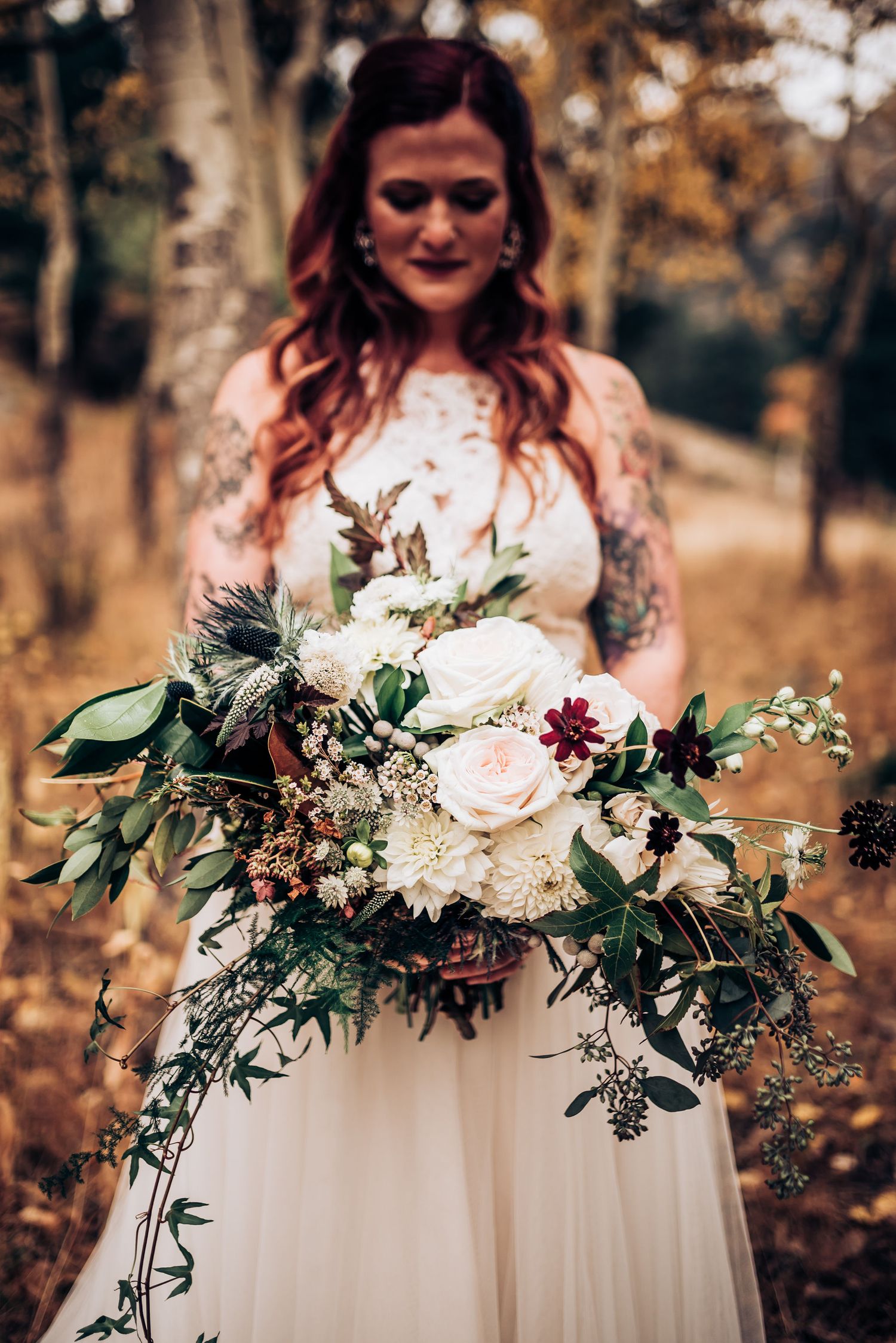 Close up of intricate bridal bouquet with white roses and cascading greenery.
