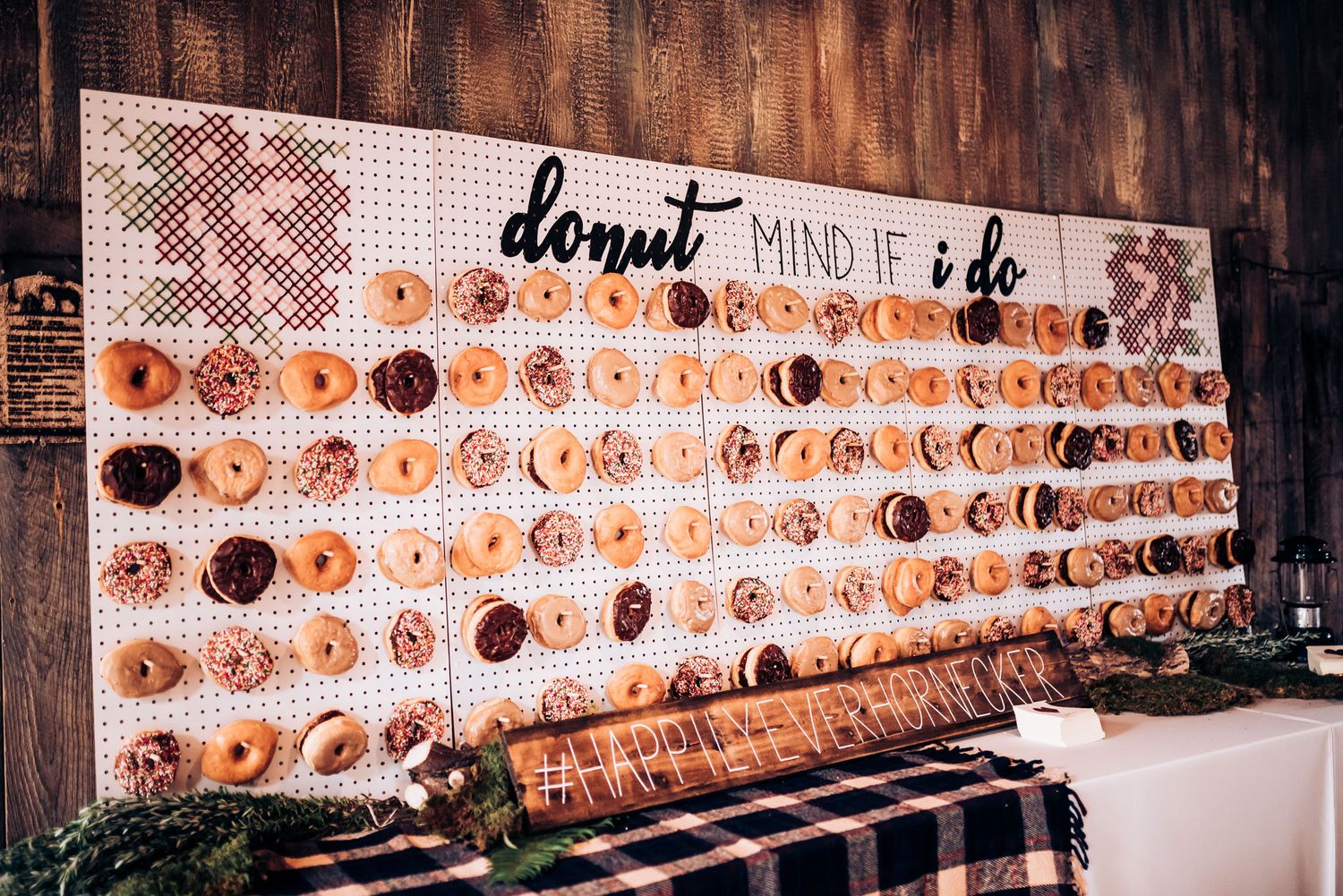 Large rustic wooden wall display featuring numerous donuts arranged in a grid pattern.