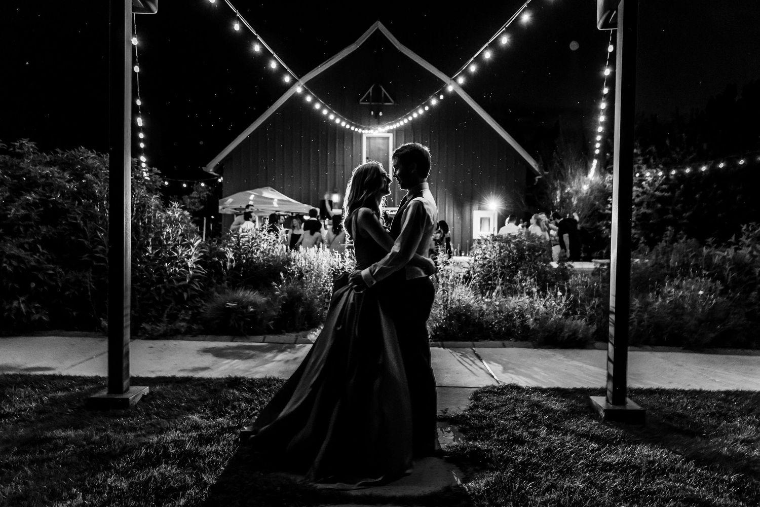 Silhouettes under string lights creating romantic nighttime ambiance.