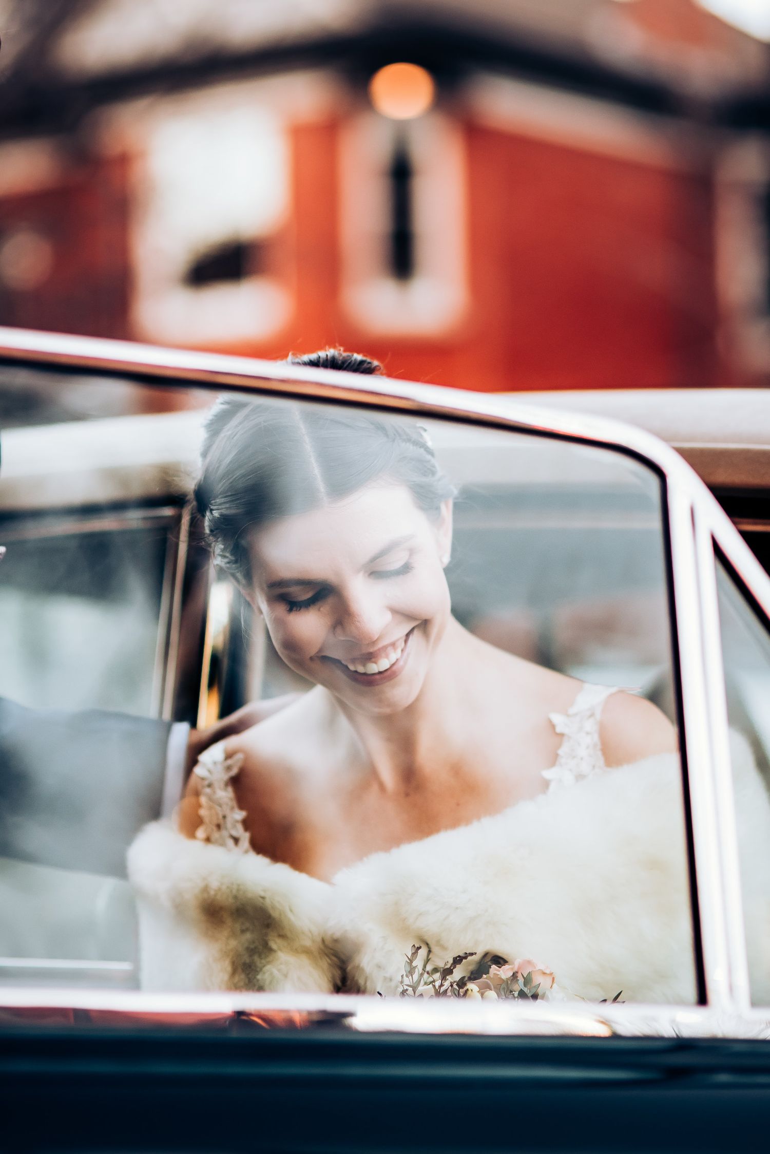 Romantic candid moment captured through vintage car window.
