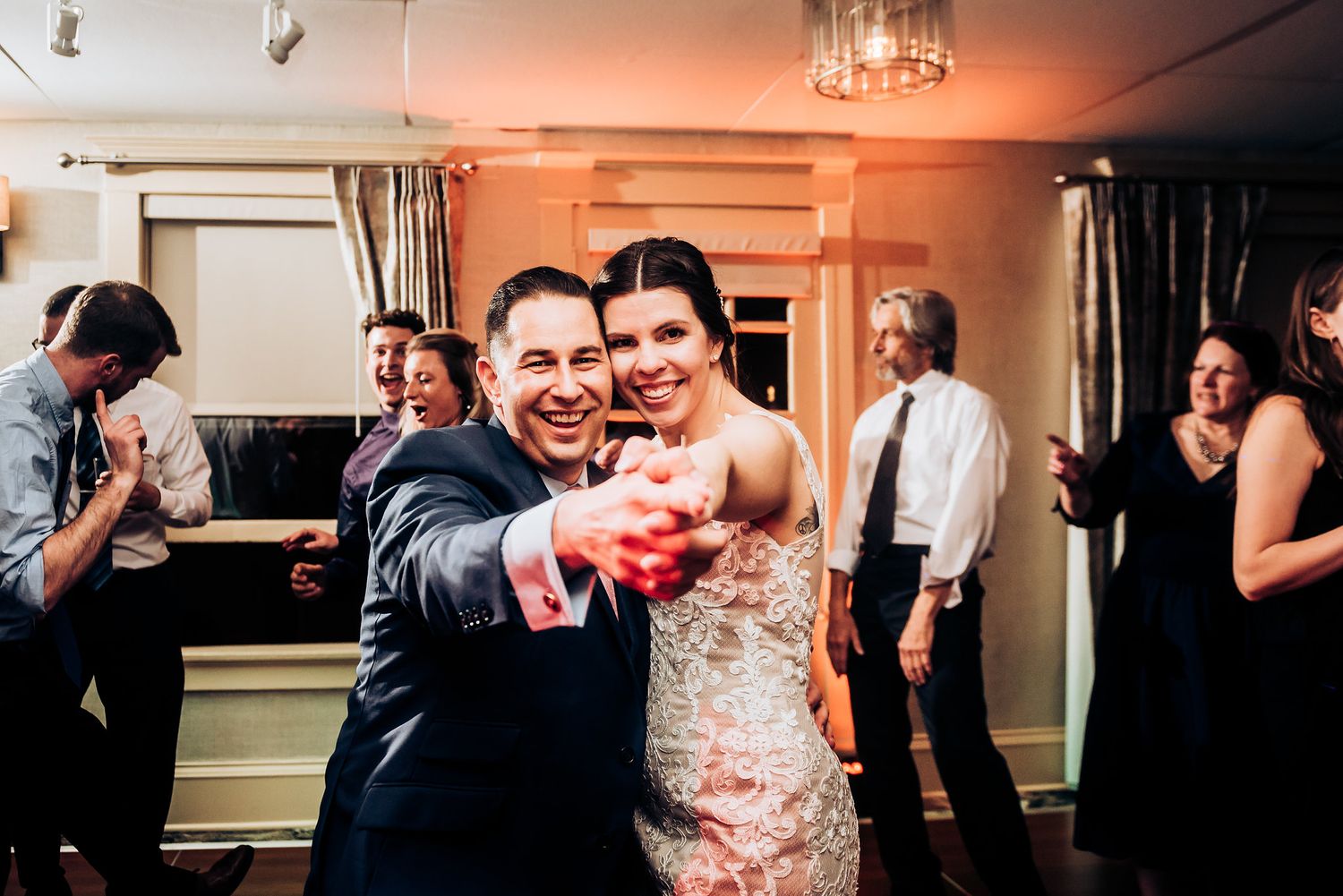 Wedding celebration on the dance floor with guests dancing in formal attire.