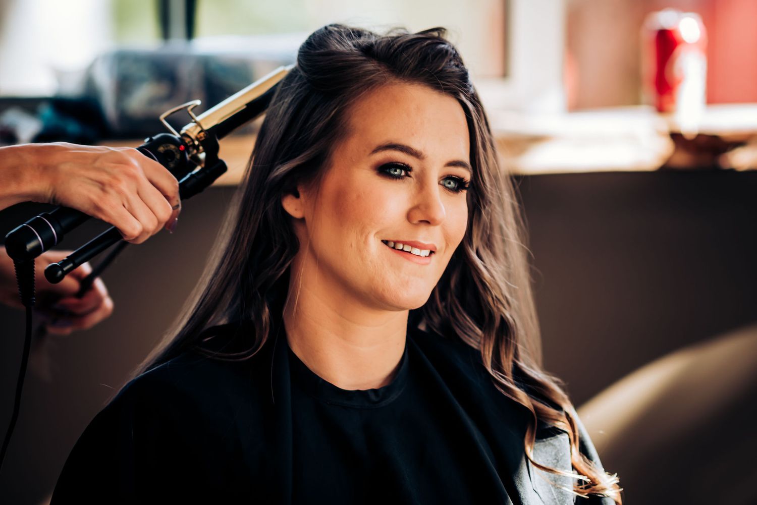 Hair styling session in progress with professional tools at salon.