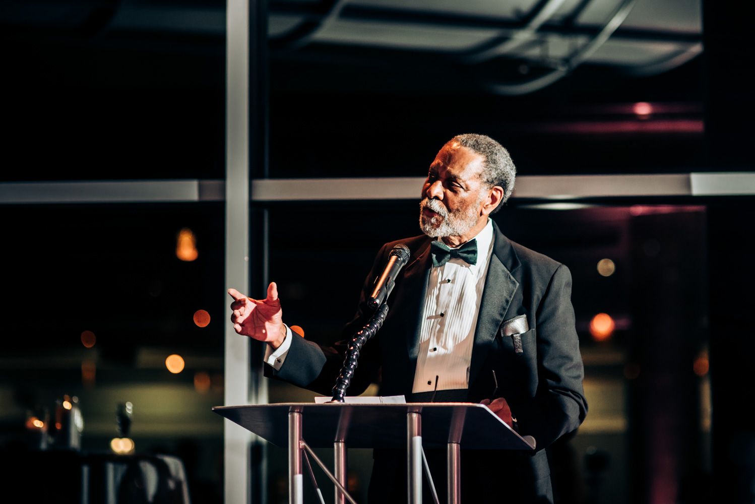 Speaker at podium delivering heartfelt speech during formal evening event.