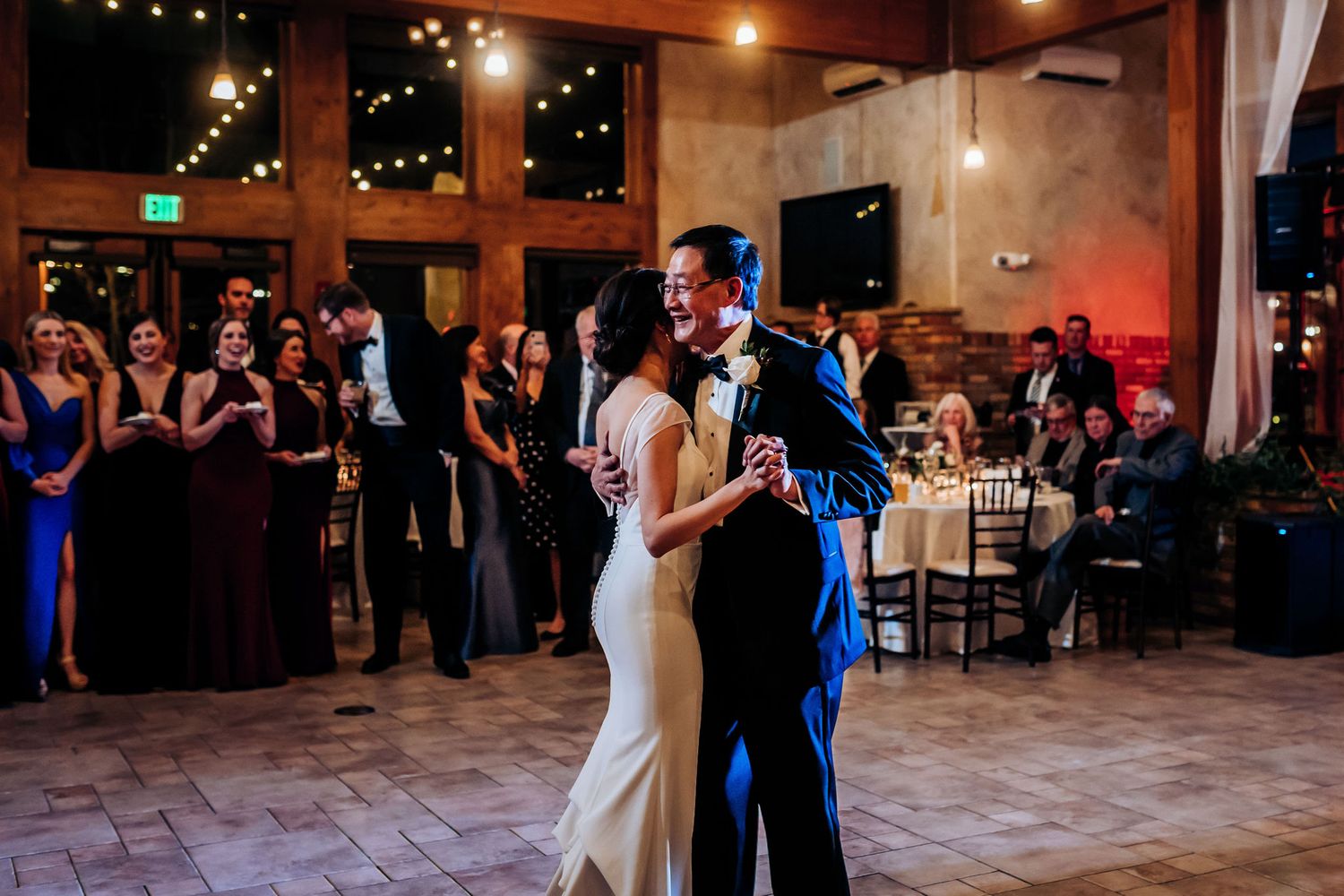 An intimate dance moment while guests watch at an evening reception.