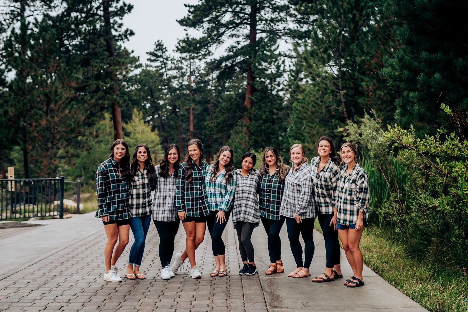 Group photo of friends wearing coordinated plaid shirts on a pathway.