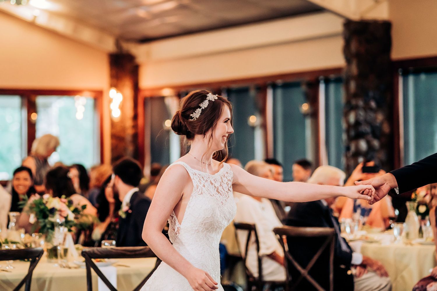 A bride in a lace dress dances gracefully during her wedding reception.