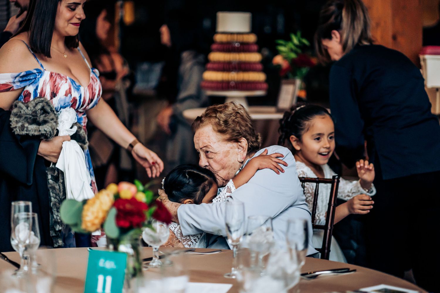 Reception guests enjoying a moment at a decorated dinner table with floral centerpieces.