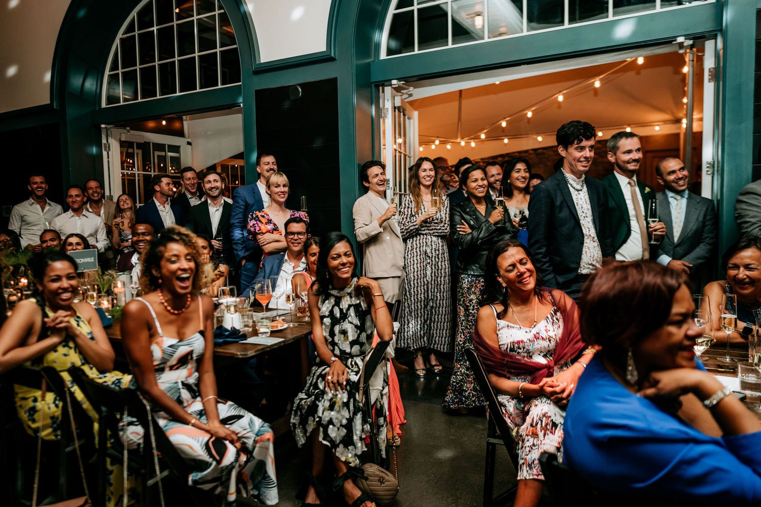 Audience members react during a live performance in a venue with green architectural details.