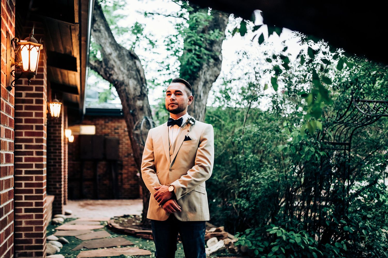 Evening portrait outside brick building with dramatic natural lighting.