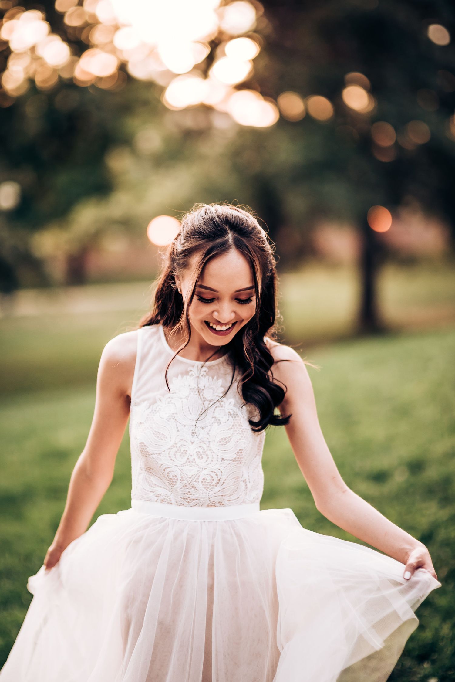 Ethereal wedding photo showcasing a joyful bride in a white lace gown twirling in a sunlit garden setting.