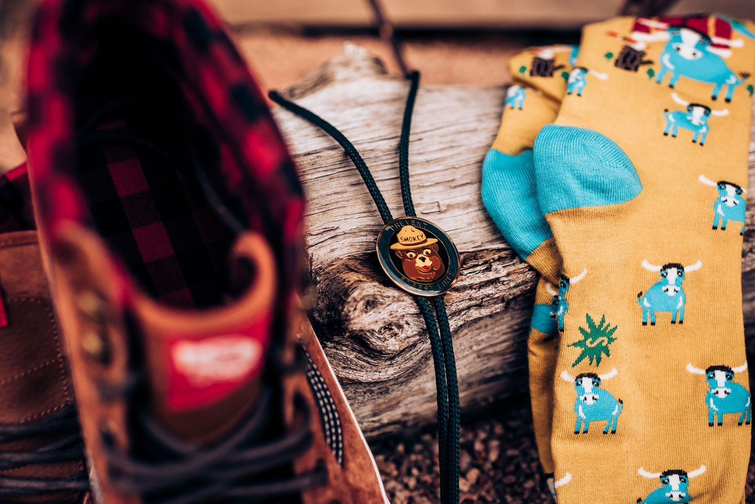 Close-up of vintage-style shoes with decorative socks and necklace on weathered wood.