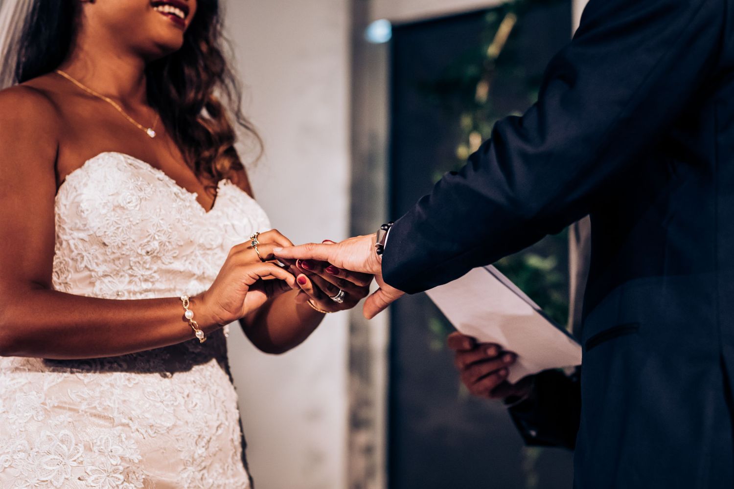 Close-up of wedding rings being exchanged during an intimate ceremony.