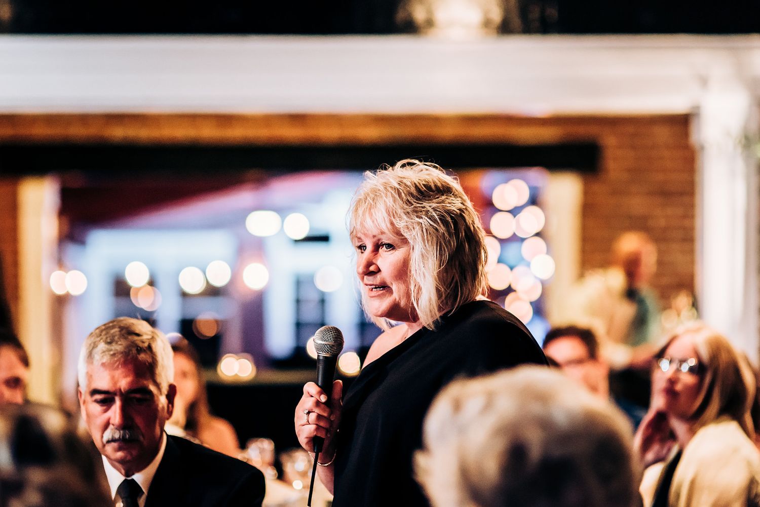 A speaker addresses guests during an evening reception event.