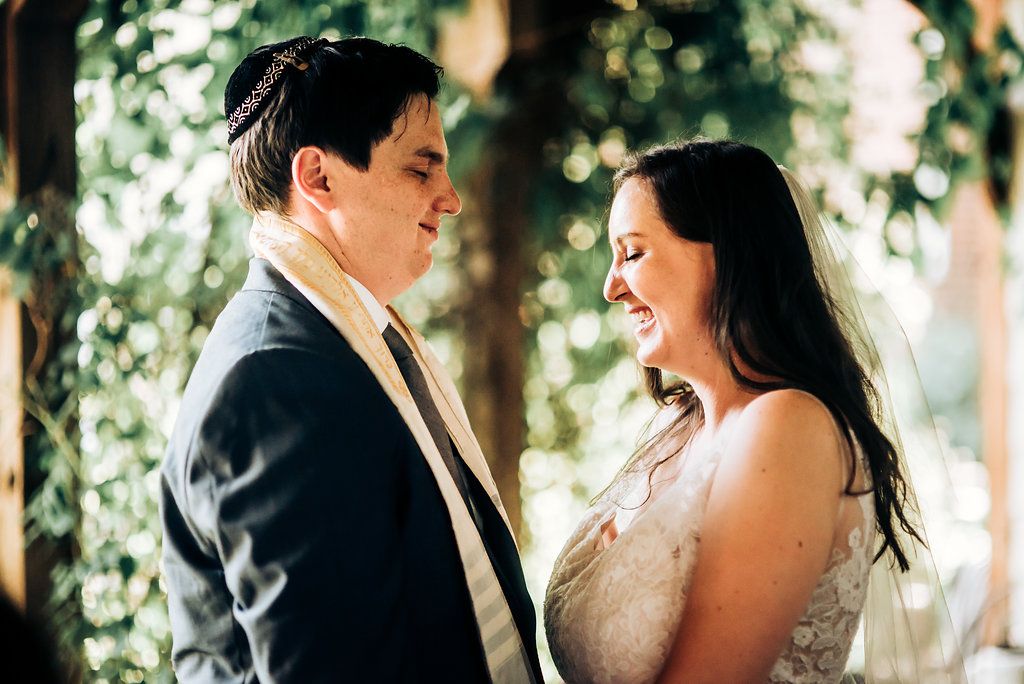 Intimate moment shared between couple during garden wedding ceremony.