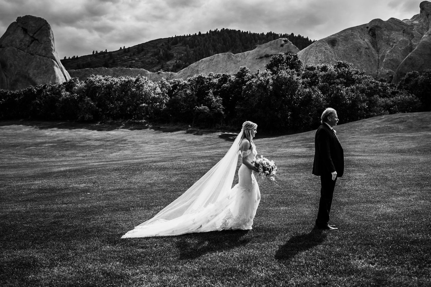 Artistic black and white wedding portrait against mountain backdrop.