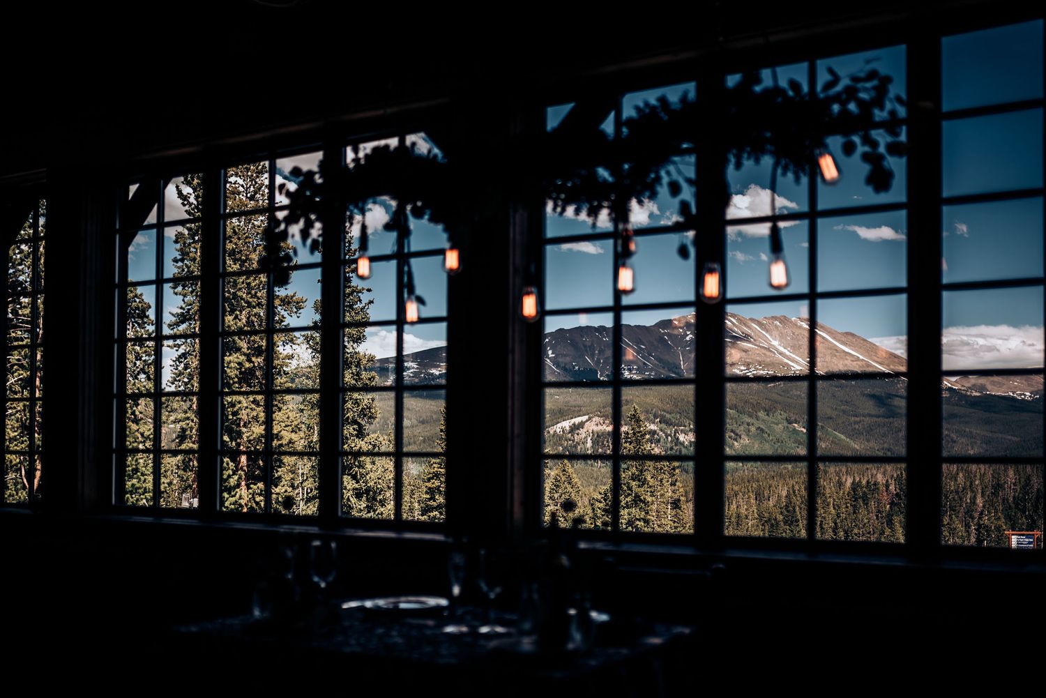 Mountain landscape viewed through large arched windows in silhouette.