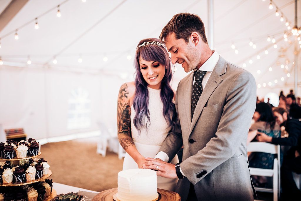 Newlyweds share a special moment while cutting their wedding cake together.