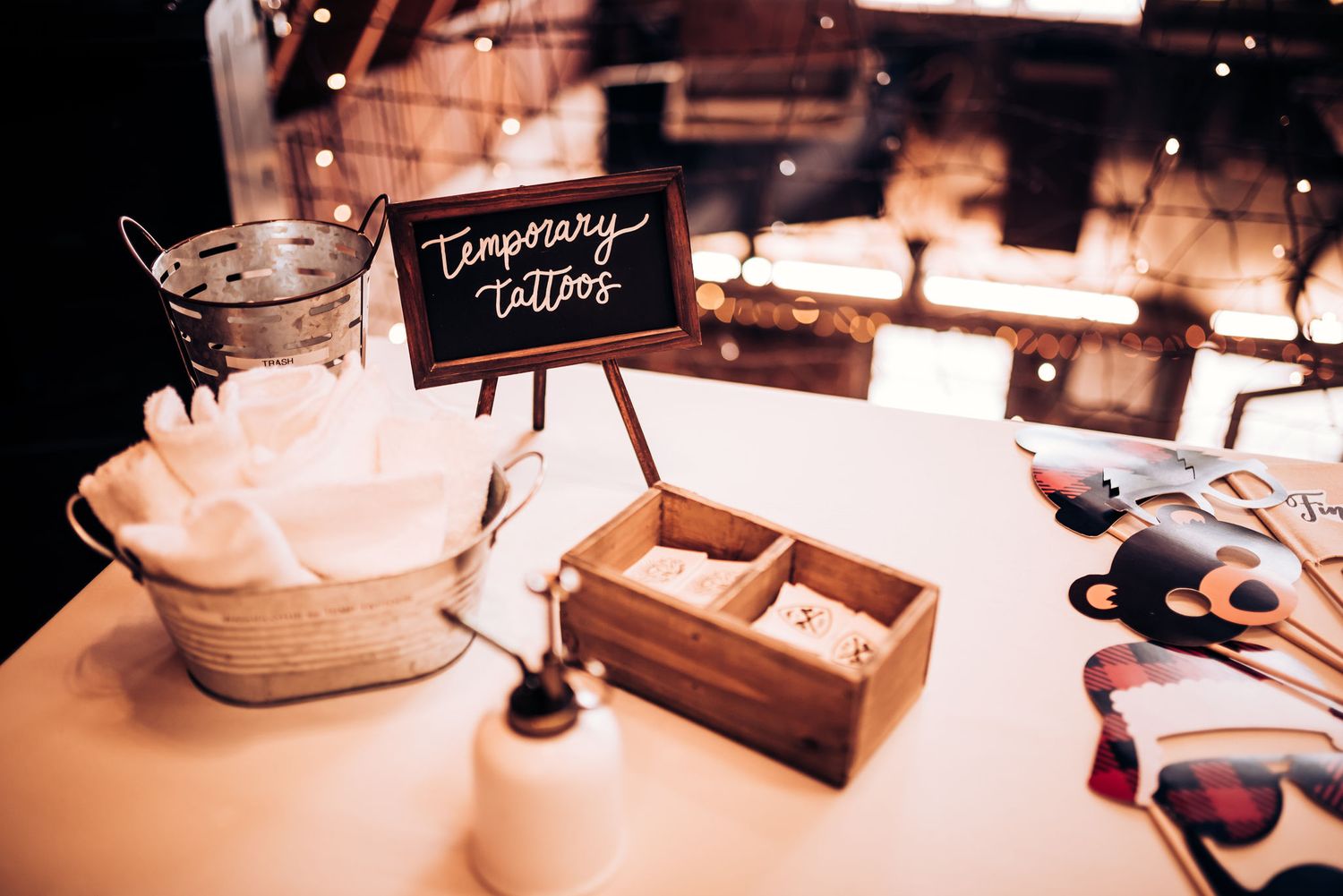 Wedding guestbook station with wooden box and decorative sign on white tablecloth.