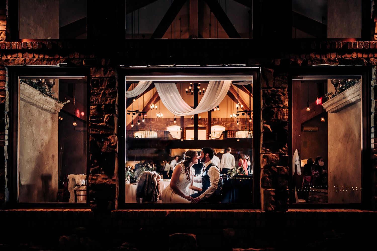 Wedding reception venue lit with warm ambient lighting and decorative elements.