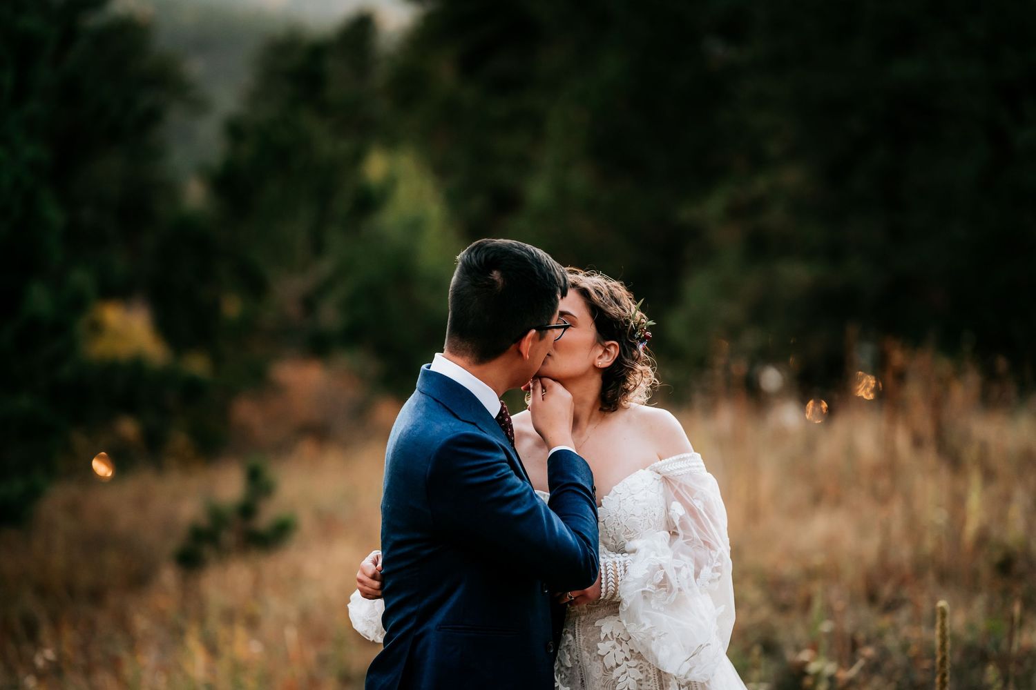 Romantic wedding portraits captured in natural outdoor setting with tall grass.