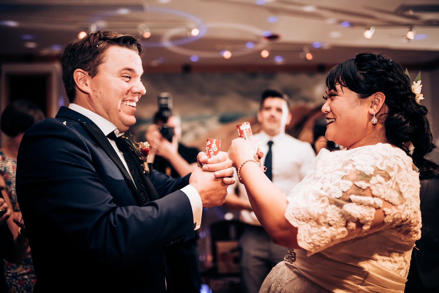 Couple sharing an energetic dance moment during their wedding reception celebration.