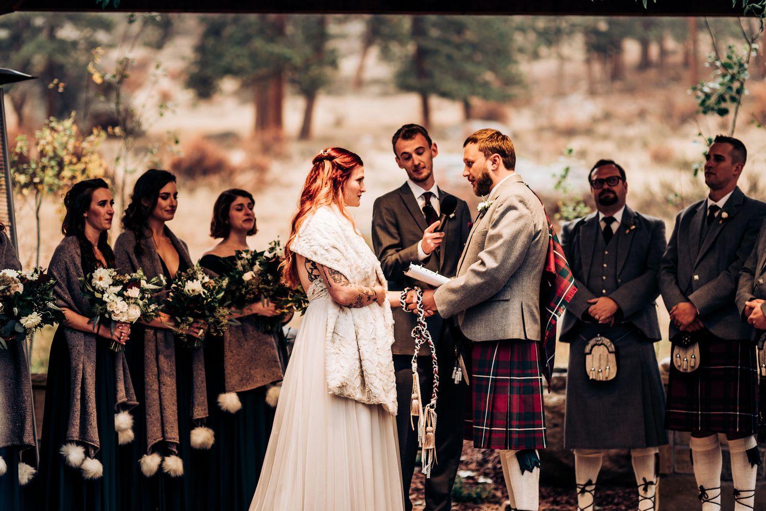 Scottish-themed wedding ceremony with couple exchanging vows while groomsmen wear traditional kilts.