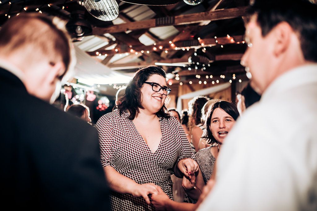 Guests enjoy a lively moment during an indoor celebration with string lights overhead.
