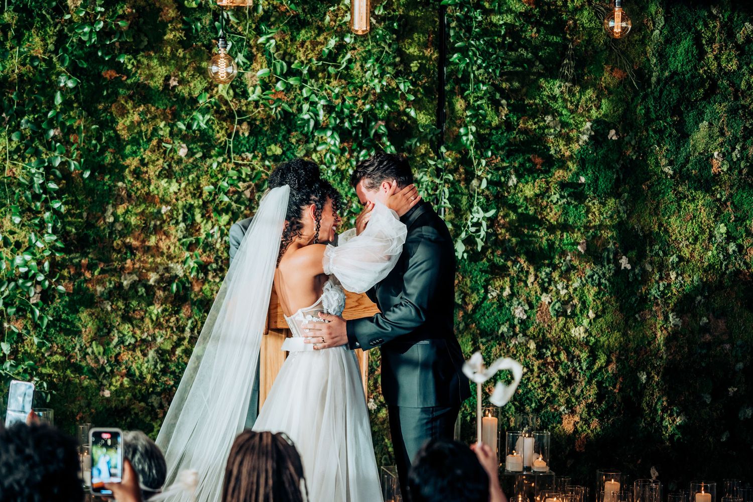 Wedding ceremony moment with elegant decor and natural greenery backdrop.