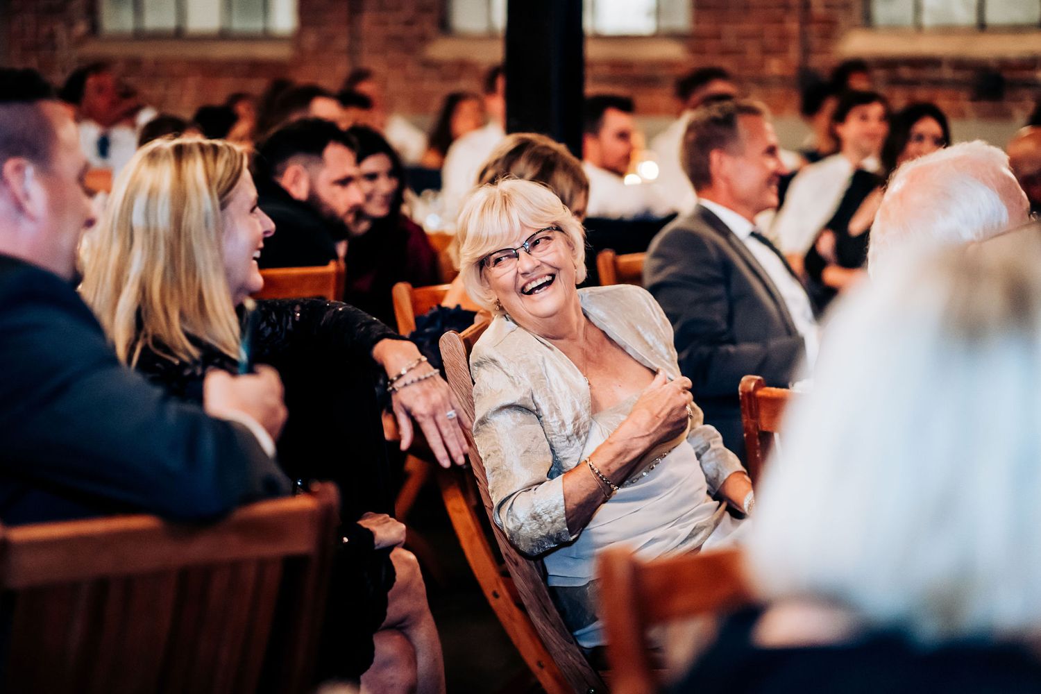 Guest reacting with joy during wedding reception entertainment.
