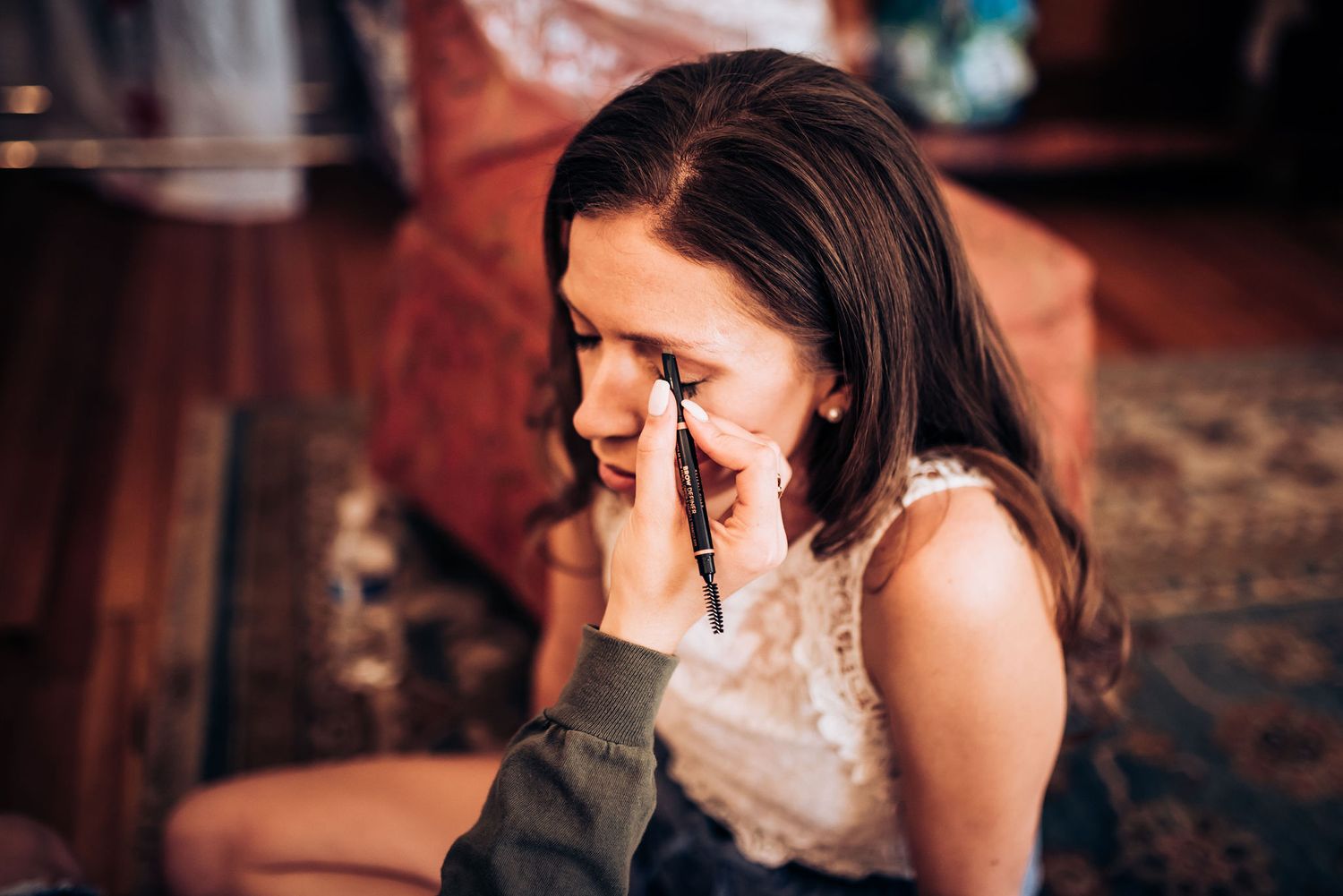 Emotional moment captured during wedding preparations in soft lighting.