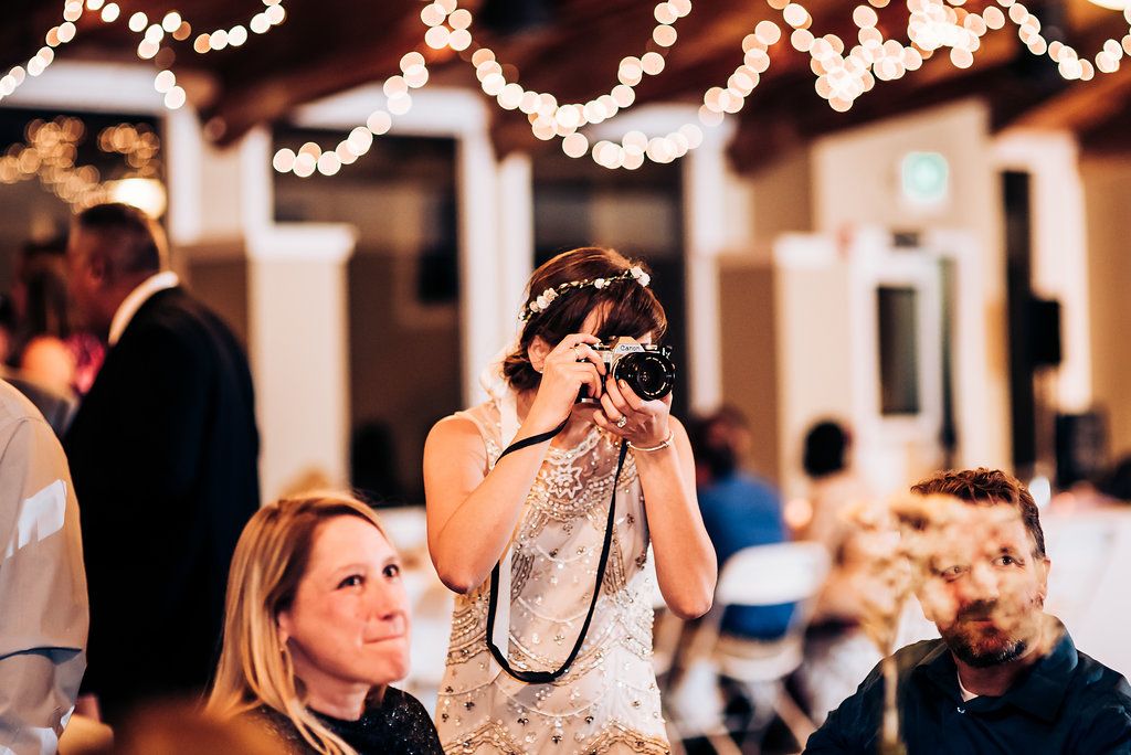 Wedding reception guest taking photos during the celebration.